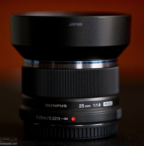 The new Olympus M.ZUIKO DIGITAL 25mm 1:1.8 lens.  Shown with supplied lens hood attached.  January 28, 2014. Photo: Edmond Terakopian   *Please forgive the particles of sand on the equipment!!*