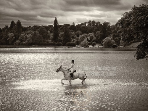 A rider gallops through the lake on her horse. Castle Leslie, Glaslough, Ireland. September 10, 2013. Photo: ©Edmond Terakopian