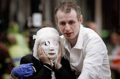 Paul Dadge leads Davinia Turrell (now Davinia Douglass) away from Edgware Road tube station after a suicide bomb attack in which she suffered burn injuries, resulting in the need for a face mask. The bomber blew himself up on a train at the station, killing seven passengers - one of four coordinated attacks on London's public transport system during the morning rush hour. The bombs exploded within 50 seconds of each other on London Underground trains, and the fourth bomb occurred on a bus less than an hour later. The explosions resulted in some 56 deaths (including those of the four bombers) and 700 injuries. Surveillance video footage showed that the four men had been working together. Intelligence services have claimed links between the bombers and al-Qaeda. Edgware Road underground station, London, United Kingdom. July 07, 2005. Photo: Edmond Terakopian